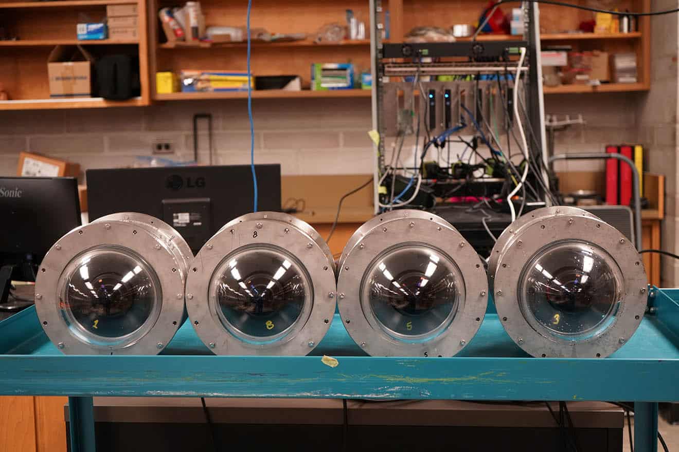 Four large round cylinder like objects on a blue table.